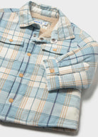 Folded plaid shirt with matching gloves on a white background