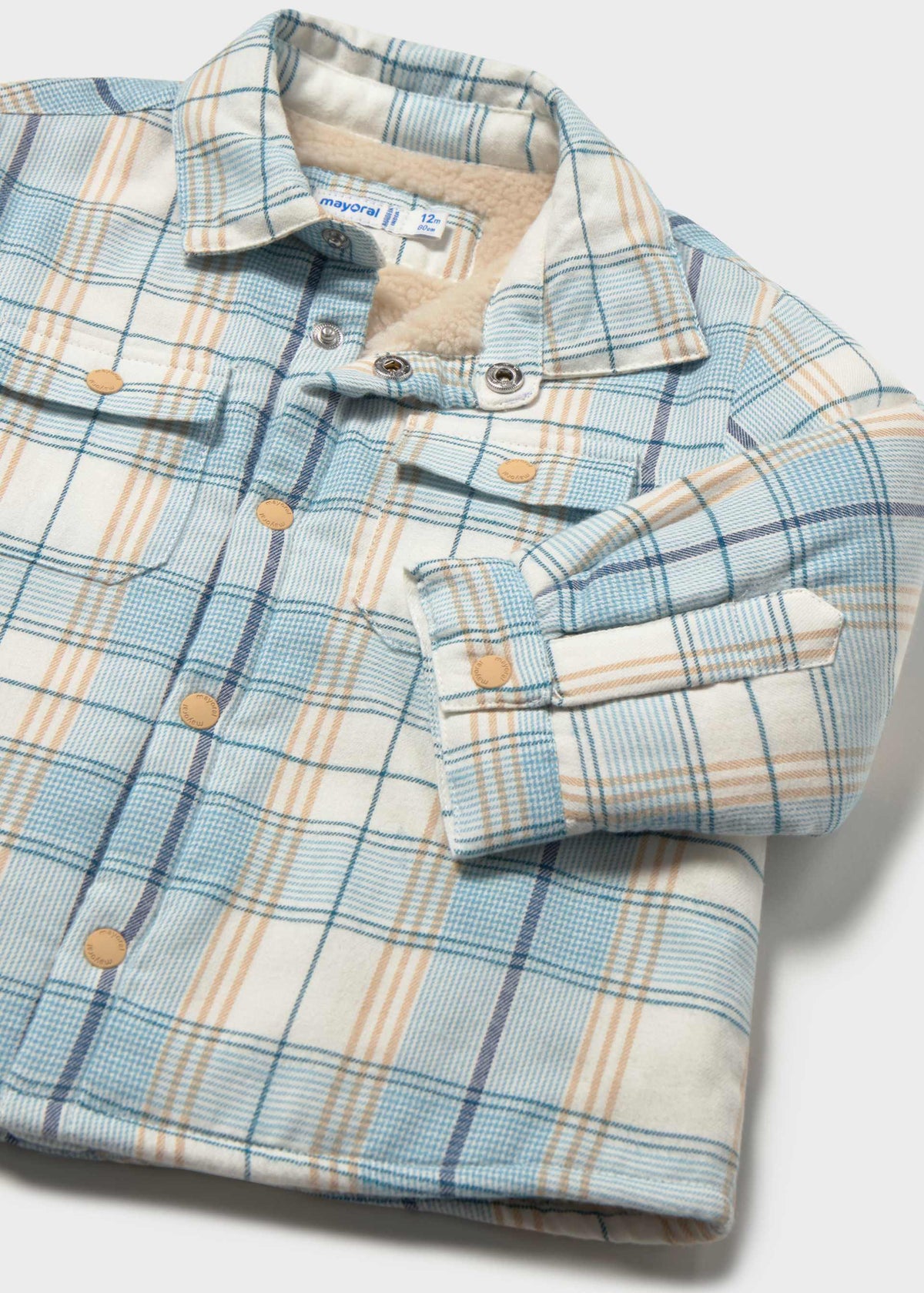 Folded plaid shirt with matching gloves on a white background