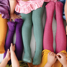 Children wearing colorful tights and socks on a light background