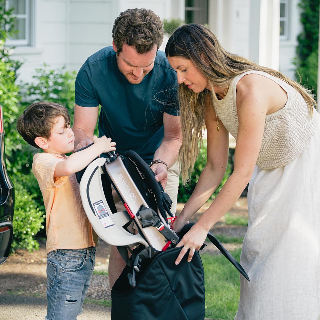 Family with a child and stroller outdoors, likely preparing for a walk.