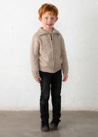 Child wearing a beige knitted sweater against a white background