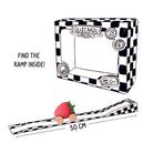A strawberry-shaped wooden toy car rolling down a 50 cm black-and-white checkered ramp that folds out from its reusable packaging box.