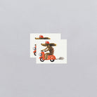 Two greeting cards with illustrations of a dog on a scooter and a cat on a motorcycle, on a light gray background.