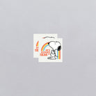 Two stickers with a cartoon dog and rainbow design on a gray background