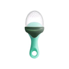 A silicone baby teether or sensory toy with a mint green handle, a dark green curved grip, and a clear silicone top covered in small raised dots, shown on a plain white background.