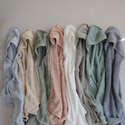 Row of folded towels in various colors against a neutral background
