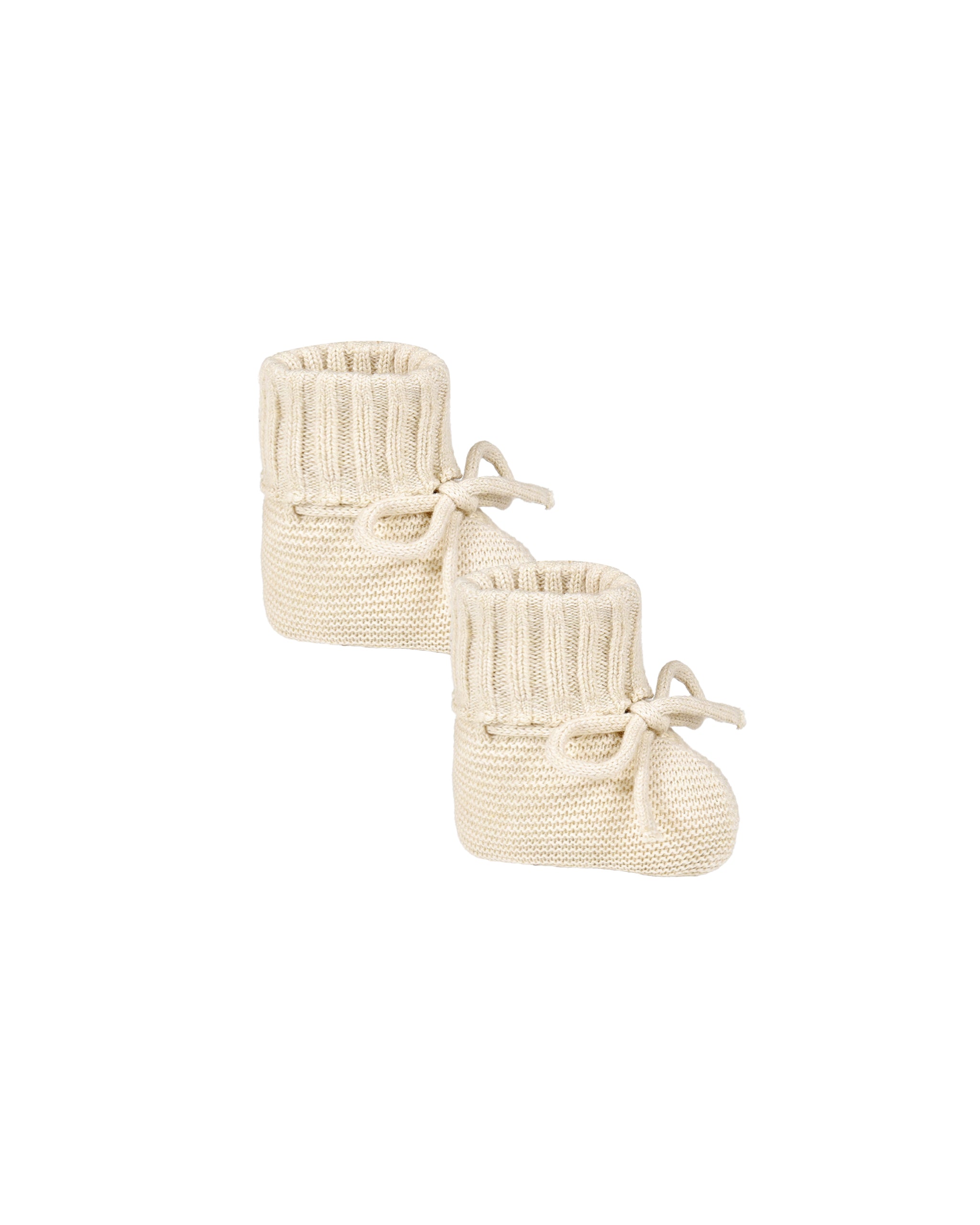 Pair of cream knitted baby booties on a white background