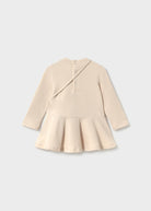 Beige peplum top on a light gray background