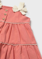 Pink dress with a bow detail on a white background