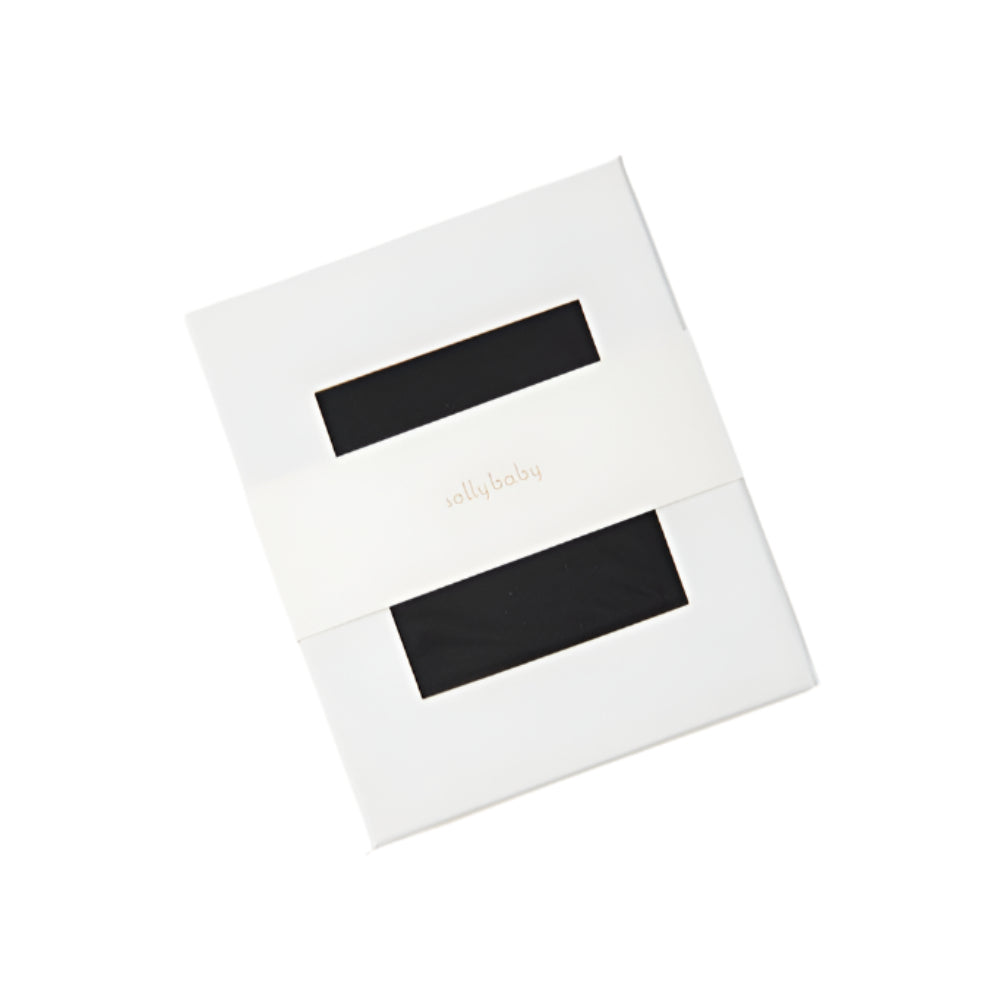 White box with black ribbons on a beige background