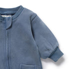 Close-up of a blue baby onesie with a zipper on a white background