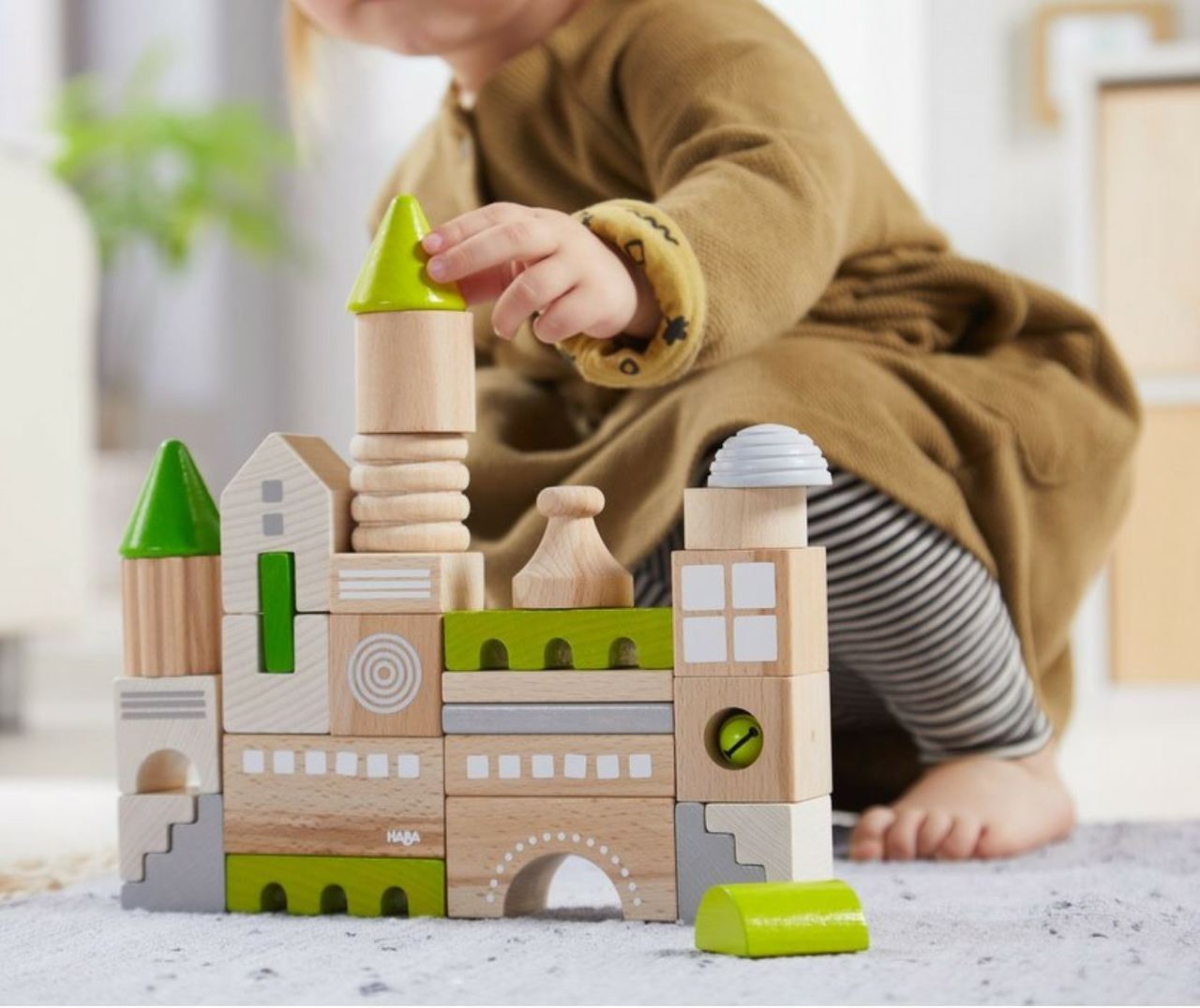 Child playing with building blocks on a rug.