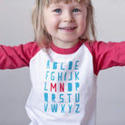 Up close image of blond girl wearing minnesota ABC shirt on a white background