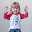 Blond girl wearing minnesota ABC shirt with jeans on a white background