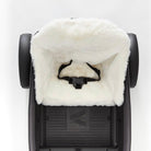 White fur seat cover a white background on a veer stroller seat
